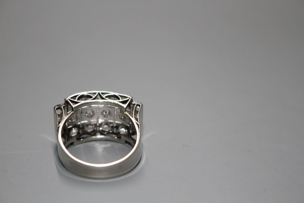 A white metal (stamped 750 and Pt 950) and pave diamond set cocktail ring, of curved design and set with twenty round cut stones.